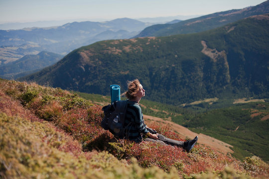 Woman sitting on mountain slope looking at view, Ukraine