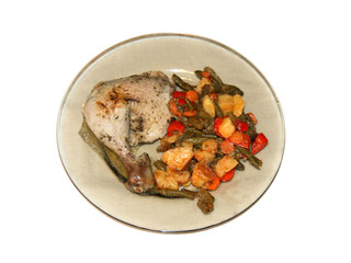 Chicken leg on a plate of vegetables.