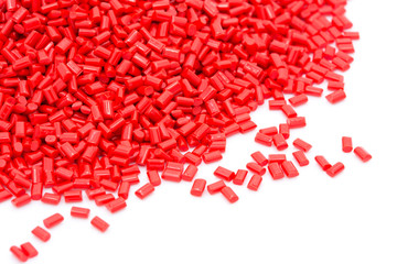 Red plastic polymer granules on white background.