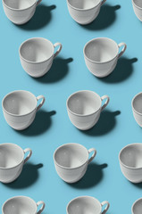 Pattern. Cup concept. Group of white cups on blue background. Creative style.