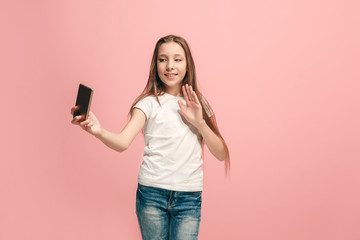 Naklejka premium The happy teen girl making selfie photo by mobile phone