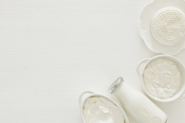 Top view image of dairy products over white wooden background. Symbols of jewish holiday - Shavuot.
