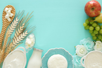 Top view image of dairy products and fruits over wooden background. Symbols of jewish holiday - Shavuot.