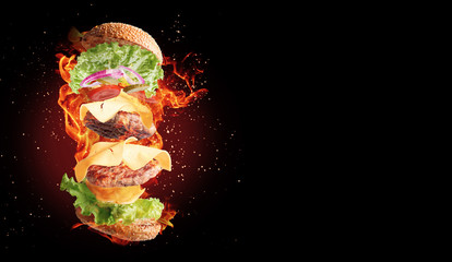a fiery flying double cheeseburger on a black background.