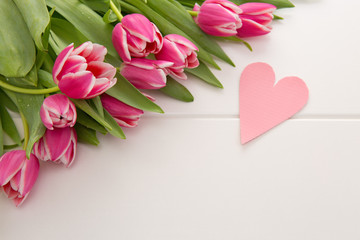 Mother's Day card and a bouquet of beautiful tulips on wooden background.