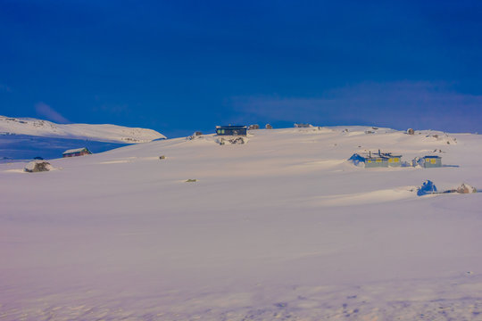 Outdoor view of some wooden houses almost covered with snow during heavy wsnowstorm, at the Gol Mountain Area