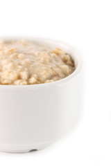 breakfast: oatmeal porridge in white bowl on white background. Isolated