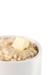 breakfast: oatmeal porridge with butter in white bowl on white background. Isolated