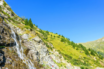 Daylight view to waterfall on the side of road in the Carpathian Mountains