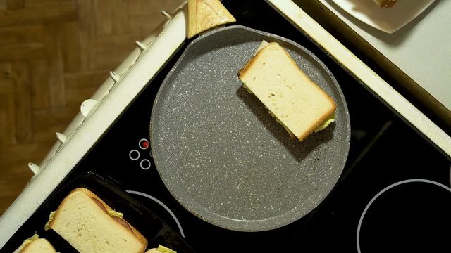 Closeup of hands prepare sandwiches in the kitchen. Fry three billets in a frying pan.