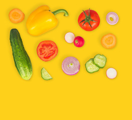 Vegetable mix on yellow isolated background. Fresh yellow pepper, chopped tomatoes, onion, round cucumber slice, carrot, radish. The concept of a healthy lifestyle. Vegetarian food.