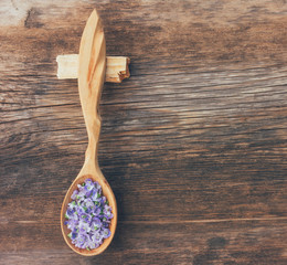 small blue flowers in wooden spoon on wooden retro background with copy space, top view