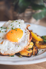 Gebratenes Spiegelei auf Bratkartoffeln mit Petersilie und Ziebeln