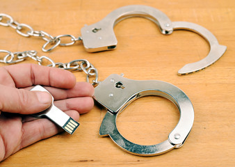 Crime, hand with handcuffs and data stick