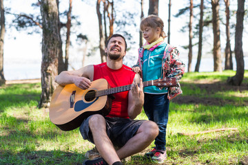 Family duet: Dad playing the guitar with his daughter, free space for your text.