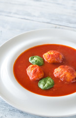 Portion of tomato soup with meatballs