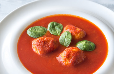 Portion of tomato soup with meatballs