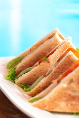 Union Club House Sandwich being serve beside the turquoise blue swimming pool or beach. Selective Focus