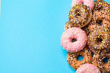 Colorful round donuts on blue background.