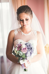 Naklejka premium Portrait of beautiful bride with fashion veil at wedding morning