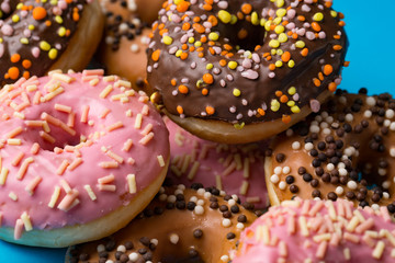 assorted donuts with chocolate frosted, pink glazed and sprinkles donuts.