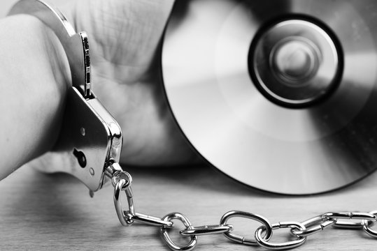 Hand mit Handschellen und Daten Disk