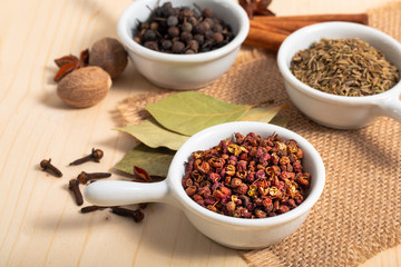Exotic spices concept Chinese Asian Spices mix  Sichuan peppercorns, star anise pods, bay leave, black peppers, nutmegs, cloves and cinnamon sticks with copy space