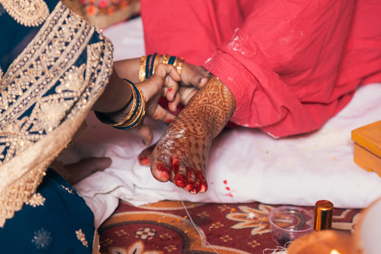 Indian bride in a Feet Coloring Ceremony during a Hindu wedding ritual.
