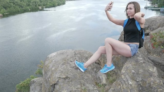a tourist girl sits on a rock