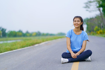 Woman sitting on the road in the park