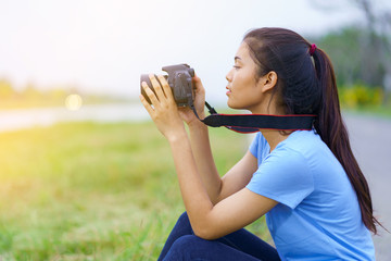 Portrait of beautiful girl in blue t-shirt and jeans smiling with a camera on hands