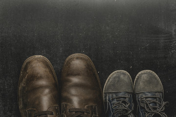 Daddy's boots and baby's shoes, fathers day concept.