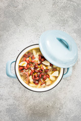 Tuscan bean soup in a pot on concrete background. Top view, space for text.