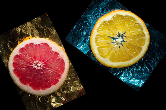 Sliced grapefruit and orange on a color foil