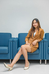 Portrait of beautiful asian business woman wear yellow dress in a office,Thailand people wear ladies uniforms office,Sexy woman on sofa