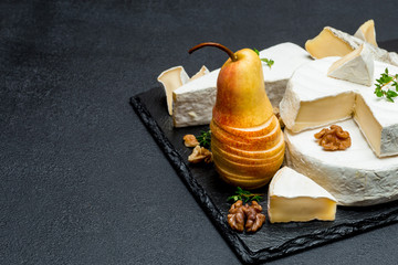 Camembert cheese and pear on stone board