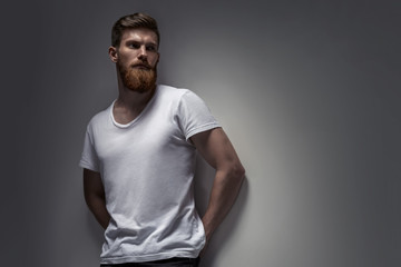 Close-up image of serious brutal bearded man on gray background Confident and dramatic concept...