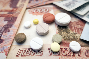 Different types of tablets located on Russian rubles close-ups