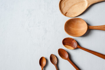 Different wooden spoons of handmade different sizes close-up.