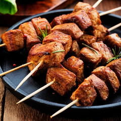 Grilled meat skewers, shish kebab on dark wooden background, top view