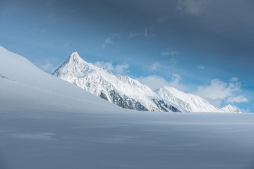 Fototapeta na wymiar Schneefläche mit verschneitem Berg im Hintergrund