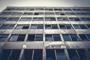 old abandoned concrete building with broken windows
