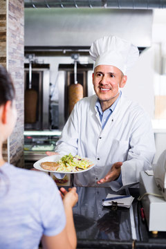 man chef  giving order with kebab