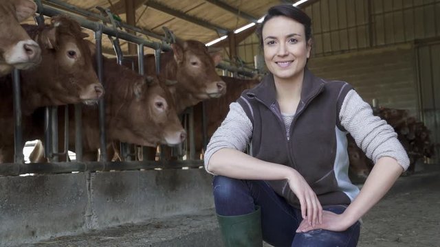 Portrait of smiling stock breeder standing in barn