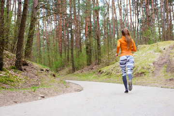 Fototapeta premium Girl in orange hoody run in forest