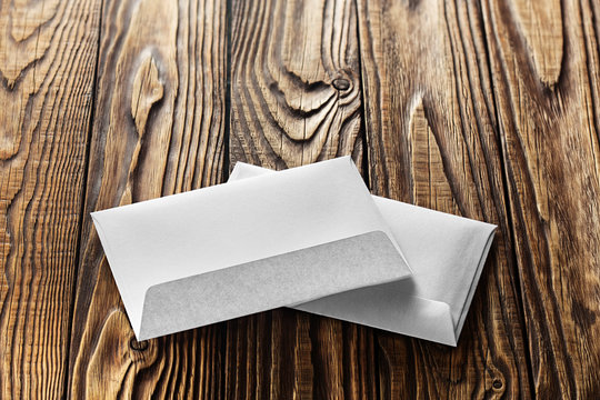 Two white envelopes with letters on old wooden dark background. Blanks for the designer. Concepts, ideas for postal services and e-mail.