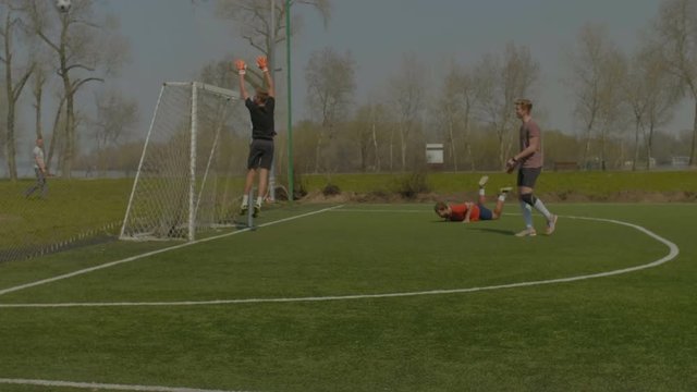 Young teenager soccer player performing corner kick while playing football match. Handsome young player heading soccer ball and missing goal after corner kick on sports field during training match.