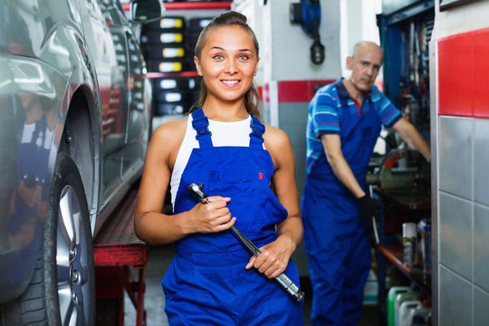Woman in work coveralls working in auto service point