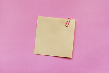 Yellow note paper label with clip on pink background