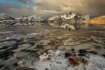 Beautiful landscape with clouds, fog, water, reflectaion in background at Lofoten Island, Norway